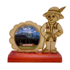 Wycinanka góral z widokiem na podstawce drewnianej.